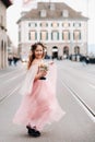 A little girl in a pink Princess dress with a bouquet in her hands walks through the old city of Zurich.Portrait of a girl in a Royalty Free Stock Photo