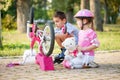 Little girl with a pink safety helmet learns how to fix bike Royalty Free Stock Photo