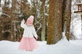 Little girl in a pink skirt in winter smiles in the park Royalty Free Stock Photo