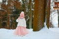 Little girl in a pink skirt in winter smiles in the park Royalty Free Stock Photo