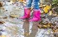 Little girl with pink wellys in the puddle