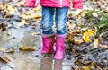 Little girl with pink wellys in the puddle