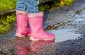 Little girl with pink wellys in the puddle