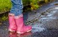 Little girl with pink wellys in the puddle