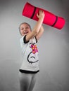 Little girl with pink yoga mat on gray background. Yoga for children mental health active lifestyle, sport fitness class