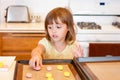 Little girl places cookie dough on cookie sheet