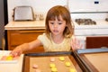 Little girl places cookie dough on cookie sheet