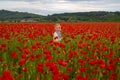Little girl play outdoor in poppy field. Lovely child on poppies background. Kids near spring blossom flowering meadow.