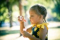 Little girl play in park blow soap bubbles profile close up Royalty Free Stock Photo