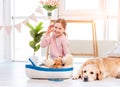 Little girl play with sea ship with golden retriever dog Royalty Free Stock Photo