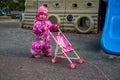 little girl play walking with toy stroller on children plyground in winter cold Royalty Free Stock Photo