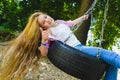 Little girl at playground. Child playing outdoors in summer. Teenager on a swing. Royalty Free Stock Photo