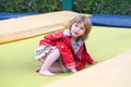 Little girl on playground in a park, jumping on trampoline. Little Girl seating on a Trampoline