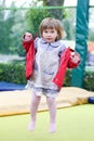 Little girl on playground in a park, jumping on trampoline Little Girl on a Trampoline Royalty Free Stock Photo