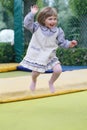 Little girl on playground in a park, jumping on trampoline Little Girl on a Trampoline Royalty Free Stock Photo