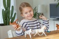 Little girl playing with animal toys on a wood table in living room Royalty Free Stock Photo