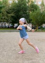 A little girl playing badminton in a yard of an apartment buiding Royalty Free Stock Photo