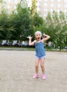 A little girl playing badminton in a yard of an apartment buiding Royalty Free Stock Photo