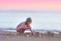 Little girl playing on the beach, making sand castle; summer and vacation Royalty Free Stock Photo