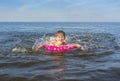 A little girl playing on the beach with splashing sea waves.  Summer holidays and healthy lifestyle concept Royalty Free Stock Photo