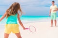 Little girl playing beach tennis on vacation with dad Royalty Free Stock Photo