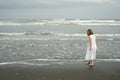 Little girl playing on beach in white dress