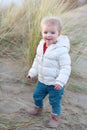 Little girl playing on the beach at winter Royalty Free Stock Photo