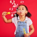 Little girl, playing or blowing bubbles on isolated red background in hand eye coordination, activity or fun game. Child Royalty Free Stock Photo
