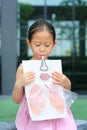 Little girl playing blowing with Simulate breathing of the lungs. Healthcare concept