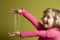 Little girl playing cats cradle game Royalty Free Stock Photo