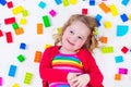 Little girl playing with colorful blocks