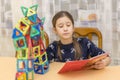 Little girl playing colorful magnet plastic blocks kit at indoor playground. girl made a toy robot. The child playing educational Royalty Free Stock Photo