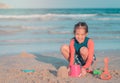 Little girl playing with colorful plastic toy and sand on the beach for kid summer vacation concept Royalty Free Stock Photo