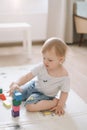 Little girl playing with colorful wooden brickes on the floor in the kids room Royalty Free Stock Photo