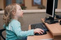 Little girl playing with computer keyboard and mouse Royalty Free Stock Photo