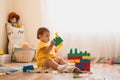 Little girl playing with construction toy blocks building a tower in a sunny kindergarten room Royalty Free Stock Photo