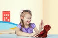 A little girl is playing doctor - she is inspecting a toy bear Royalty Free Stock Photo