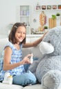 Little girl playing doctor with toy bear in facial mask Royalty Free Stock Photo