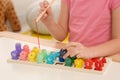 Little girl playing with Educational game Fishing for Numbers at desk indoors, closeup. Learning mathematics with fun Royalty Free Stock Photo