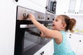 Close-up Of Girl`s Hand Touching Electric Oven