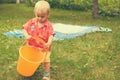 Little girl is playing with an empty bucket.