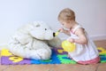 Little girl playing feeding her teddy bear Royalty Free Stock Photo