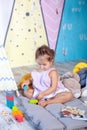 Little girl is playing on floor with colorful cubes. Baby plays with toys in children`s room. little girl plays in kindergarten. c Royalty Free Stock Photo