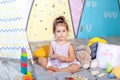 Little girl is playing on floor with colorful cubes. Baby plays with toys in children`s room. little girl plays in kindergarten. c Royalty Free Stock Photo