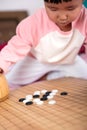 A little girl playing go seriously Royalty Free Stock Photo
