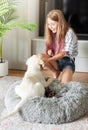 Little girl playing with a golden retriever puppy at home Royalty Free Stock Photo