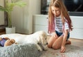 Little girl playing with a golden retriever puppy at home Royalty Free Stock Photo