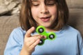 Little girl playing with green fidget spinner toy Royalty Free Stock Photo