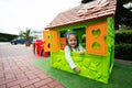Little girl playing in green plastic kid house at children\'s playground. Child having fun outdoors Royalty Free Stock Photo