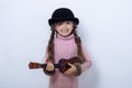 Little girl playing guitar on a grey wall background. Funny kid girl with ukulele guitar. Royalty Free Stock Photo